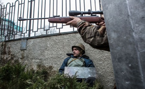 Một tay súng của phe BT nhắm bắn về hướng có hỏa lực bắn tỉa gần khách sạn Ukraine hôm 20/2 (Getty Images)