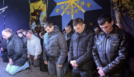 Cảnh sát chống bạo động quỳ gối xin lỗi người dân ở thành phố Lviv. Ảnh: Reuters.