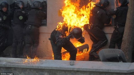 Có viên cảnh sát bị trúng bom xăng và bốc cháy (Getty Images)